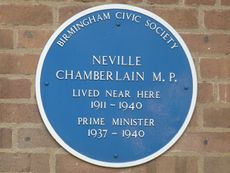 Round blue plaque on a brick wall. It says "BIRMINGHAM CIVIC SOCIETY", "NEVILLE CHAMBERLAIN M.P.", "LIVED NEAR HERE 1911–1940", "PRIME MINISTER 1937–1940".
