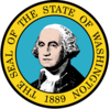A circular seal with the words "The Seal of the State of Washington, 1889" centered around it from top to bottom. In the center, a man with gray hair poses.