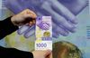 An employee of Swiss National Bank (SNB) presents the new 1,000-franc banknote.jpg