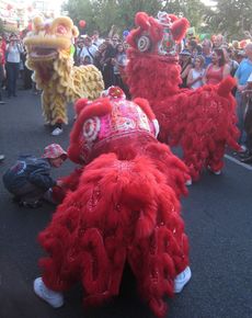 Lion dancers wearing bright red and yellow costumes
