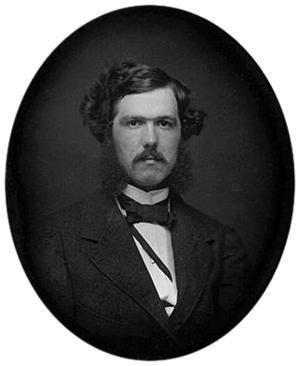 Black-and-white photograph of a young man with a mustache