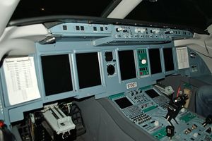 View of cockpit of modern jet airliner, showing a large array of displays and instruments.