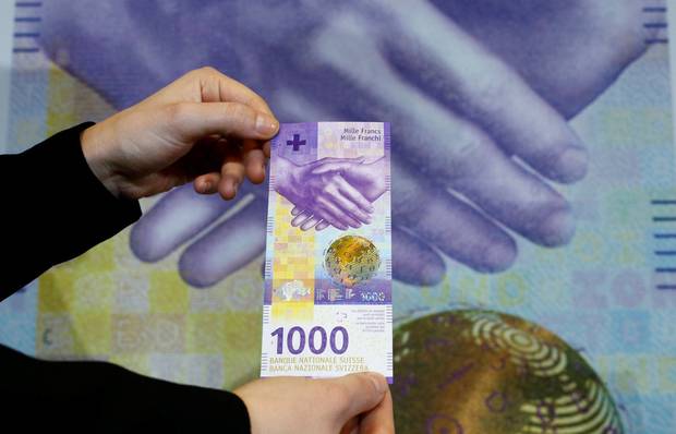 ملف:An employee of Swiss National Bank (SNB) presents the new 1,000-franc banknote.jpg