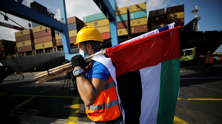 ملف:عامل يحمل علمي الإمارات وإسرائيل، ميناء حيفا، 2020.jpg