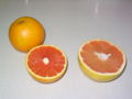 Picture of a Cara Cara orange (left) with a pink grapefruit for comparison of size and colour.
