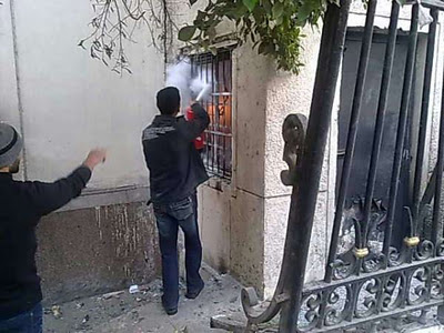 ملف:شاب من المتظاهرين يحاول اخماد حريق مبنى المجمع العلمي.jpg