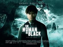 شاب شاب ذو شعر داكن يرتدي ملابس إدواردية يقف في مقبرة ضبابية ، مع خلفه صورة مقنعة. فوقهم هو عنوان "المرأة في الأسود".