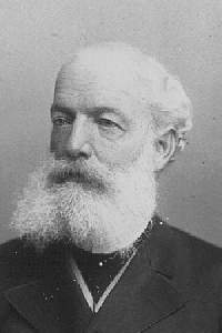 A black and white image of a bald man in a dark outfit, with a bushy white beard and moustache