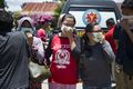 People wear masks as they try to identify the bodies of their relatives at a police hospital in Palu.jpg