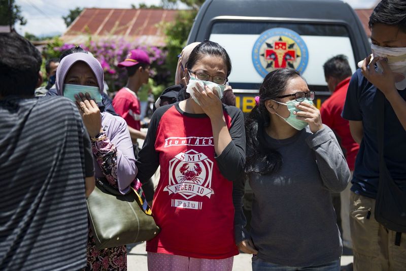 ملف:People wear masks as they try to identify the bodies of their relatives at a police hospital in Palu.jpg