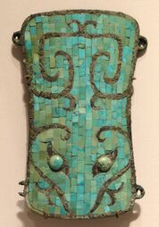 Ornamental bronze plaque inlaid with turquoise pieces