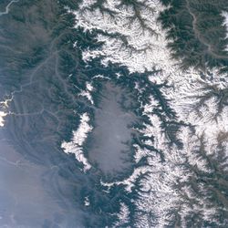 وادي كشمير من الفضاء. قمم سلسلة پير پانجال تغطيها الثلوج (يسار الصورة؛ الجنوب الشرقي على البوصلة) والهيمالايا (يمين الصورة؛ الشمال الشرقي على البوصلة) جانب الوادي.