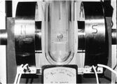 A tin cylinder—in a Dewar flask filled with liquid helium—has been placed between the poles of an electromagnet. The magnetic field is about 8 millitesla (80 G).