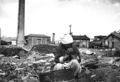 An aged Korean woman pauses in her search for salvageable materials among the ruins of Seoul, Korea. November 1, 1950. Capt. C. W. Huff. (U.S. Army)