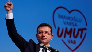 Ekrem İmamoğlu speaks at a rally with a heart graphic in the background.jpg