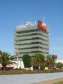 A building rooftop supporting numerous dish and sectored mobile telecommunications antennas (Doncaster, Victoria, Australia.