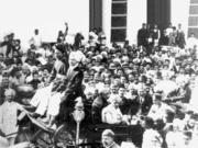 مهندس كرمچند غاندي (جالساً في العربة، على اليمين، عيناه مسدلة، ويرتدي قبعة مسطحة) يلقى ترحيباً كبيراً في كراتشي عام 1916 بعد عودته للهند من جنوب أفريقيا.