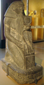 تمثال راكع لسننموت ممسكاً بإسم حتشپسوت، يوجد الآن في متحف بروكلين.