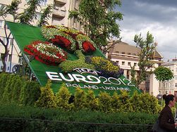 Goat-emblem of Poznań dressed in Euro 2012 flags (left) and the Euro 2012 logo made of flowers in Lviv (right).