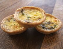 Three small individual quiches with mushrooms and pale custard filling