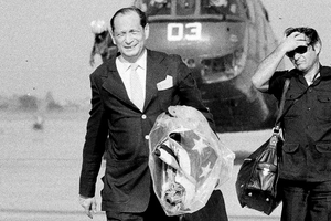 جون غونتر دين يمسك بالعلم الأمريكي بعد إجلاءه هو وموظفين آخرين من كمبوديا إلى تايلاند في أبريل 1975.png