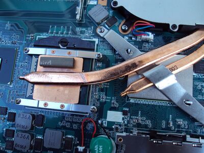 A laptop computer's CPU and GPU heatsinks, and copper heat pipes transferring heat to an exhaust fan expelling hot air