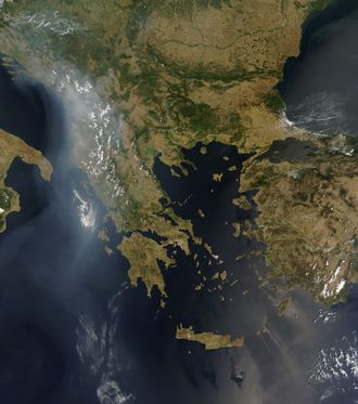 A satellite view of the Balkans and Greece. Clouds and smoke trails are seen above the Balkans and trailing south into the Ionian Sea.