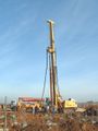 Iron bar reinforced foundation piles are driven with a drilling machine, concrete pump, mixer-truck, and a specialized auger that allows pumping concrete through its axis while withdrawn.