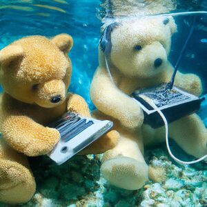 An image generated by DALL-E 2, from the prompt Teddy bears working on new AI research underwater with 1990s technology