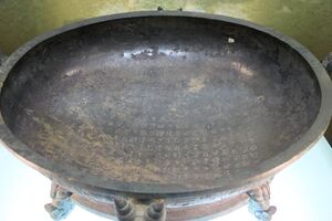 a broad bronze pan, with a lengthy inscription on the flat area inside