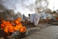 محتجون يبنون أسوار عازلة ويشعلون النيران في الإطارات لحمايتهم من قوات الأمن السودانية أثناء فض اعتصام القيادة العامة بالخرطوم.