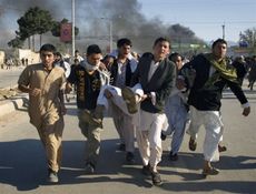 أفغان يحملون مصابا بعد الهجوم على مقر الأمم المتحدة في مزار شريف 1 أبريل 2011.jpg