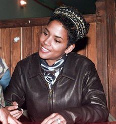 Dressed in brown leather jacket, Berry looks up smiling.