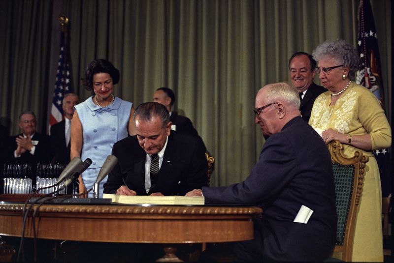 ملف:Lyndon Johnson signing Medicare bill, with Harry Truman, 30 July, 1965.jpg