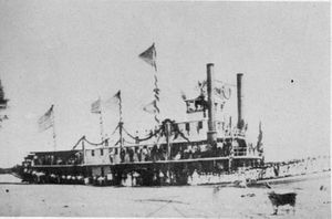 Black and white photograph of a docked sternwheeler with two funnels