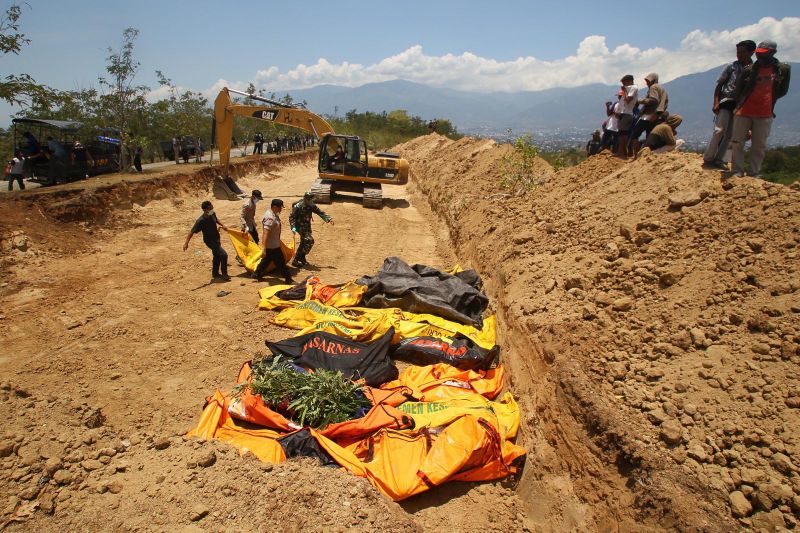 ملف:Bodies are carried to a mass grave in Palu's Balaroa village on October 1.jpg