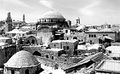 صورة فوتوغرافية سپيا تعطي مشهد پانورامي للكنيس وجواره. ويقع الكنيس في الوسط ويرتفع فوق المباني المحيطة.