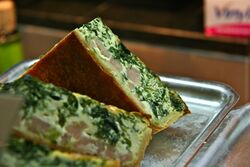 Slices of a quiche with a green and yellow fillings
