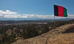 العلم الوطني الأفغاني يشرف على وادي من مرصد في ولاية پكتيكا في أفغانستان.