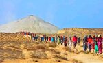 Pilgrims heading to a volcano in an arid landscape