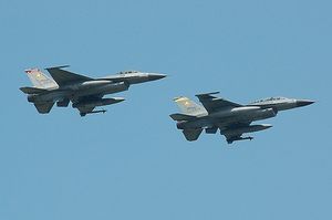 Two grey jet fighter aircrafts over a blue sky