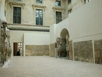Louvre – human-headed winged bulls and reliefs from Dur-Sharrukin, in their wider setting of reliefs