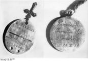 "Military Dog tag" and Christian medallion recovered from the graves. The inscription reads: "In memory of Holy Baptism, Cracow, 24 October 1909".