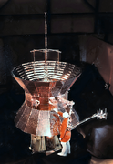 A technician stands next to one of the twin Helios spacecraft