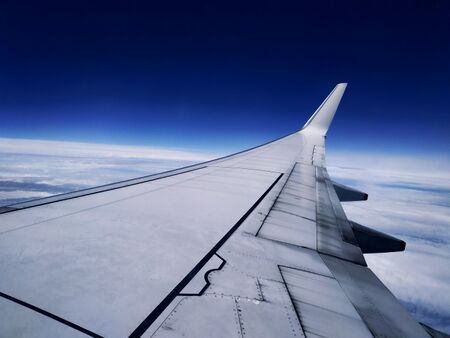A generic Boeing 737-800 cruising at 32,000 feet. Below it are a pack of clouds. Above it is a vivid, ambient blue sky.