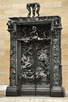 Ornate, bronze door panels and frame showing figures and scenes in relief.