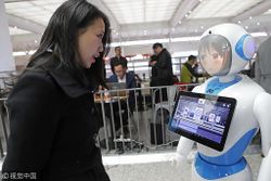 A woman interacts with a 5G smart robot at Shanghai Hongqiao Railway Station on Feb 18 2019.jpeg
