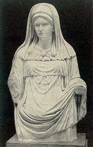 تمثال لـ عذارى ڤستا ترتدي سترة بيضاء وحجاب أبيض.