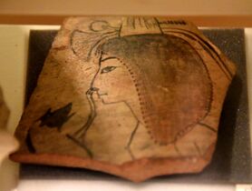 كسرة من إناء خزفي تظهر قردًا يخدش أنف فتاة. الأسرة العشرون. من ما يسمى بمدرسة الفنانين في رامسيوم، طيبة، مصر. متحف پيتري للآثار المصرية بلندن