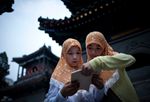 فتاتان من الهوي يقرأون القرآن بمسجد في بكين، الصين، 1 أغسطس 2011.